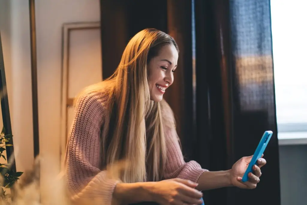 European girl using mobile phone at home